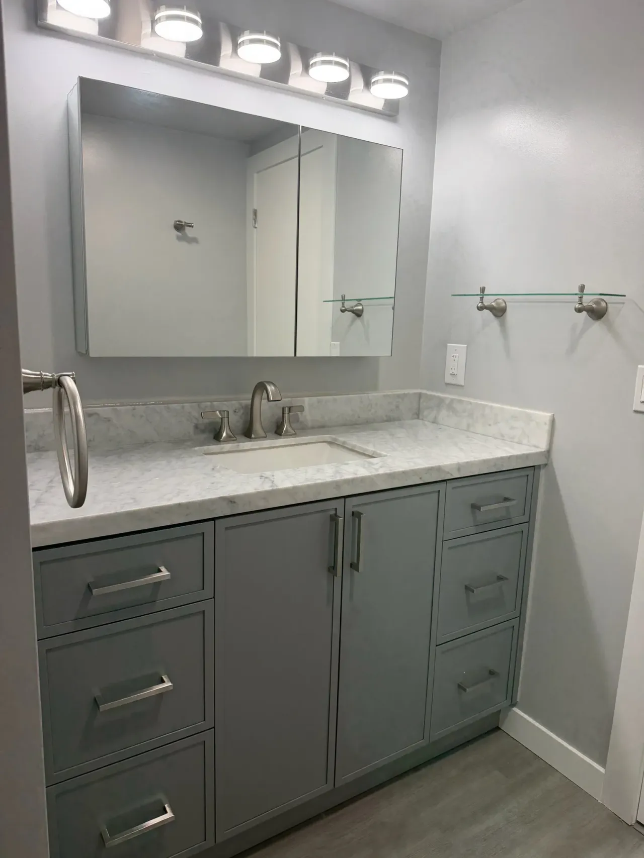 Custom grey shaker vanity with white marble countertop and brushed nickel fixtures